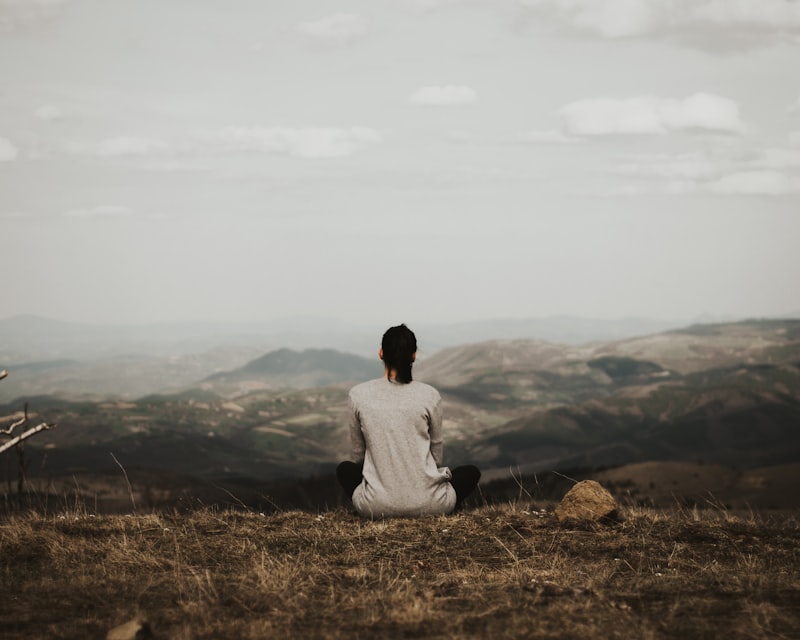 A figure sitting in stillness on a misty shore — coaching