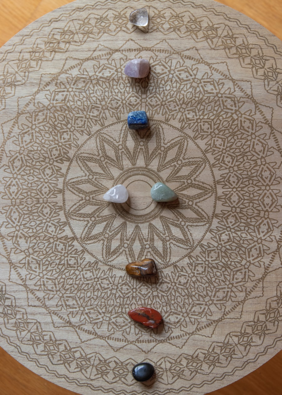 Chakra-coloured healing stones in a sacred mandala — intuitive Reiki